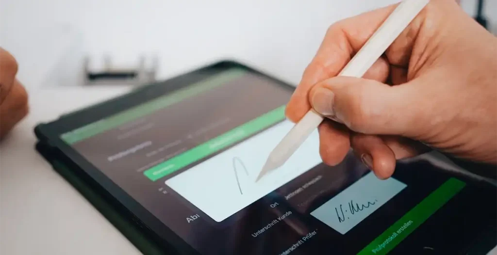 Ein Gewerbetreiber unterschreibt einen Vertrag mit einem digitalen Stift auf einem Tabletbildschirm