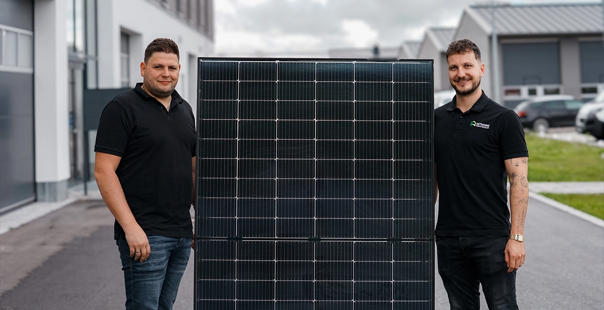 Patrick Hurle von SIGNAL IDUNA und Markus Zink, Geschäftsführer von IntHome Elektrotechnik GmbH in Augsburg, präsentieren ein Solarmodul für Photovoltaik und PV-Versicherung