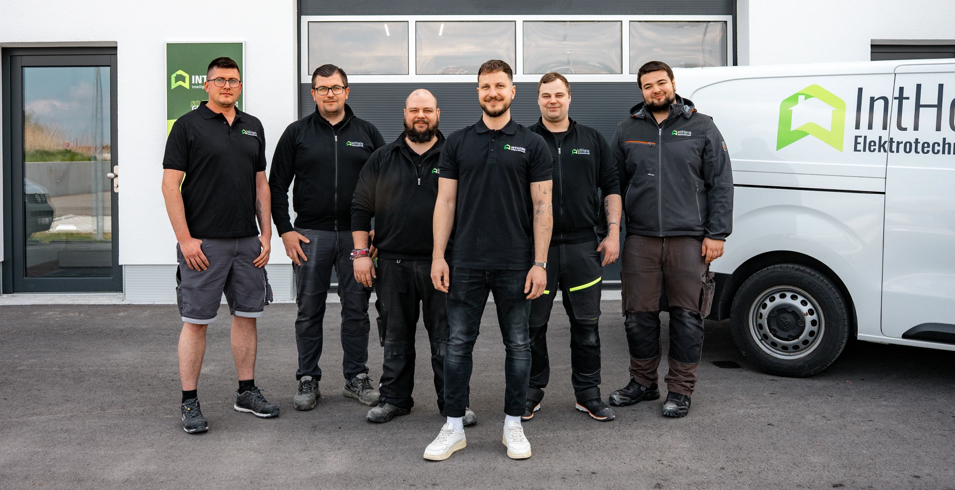 Team von IntHome Elektrotechnik am Firmenstandort in Gablingen vor Garage und Firmenfahrzeug