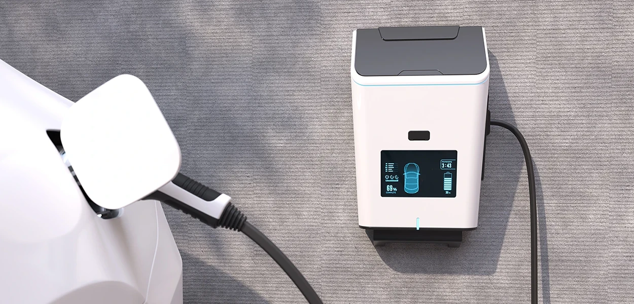 Eine moderne, weiße Wallbox lädt ein Elektroauto auf.